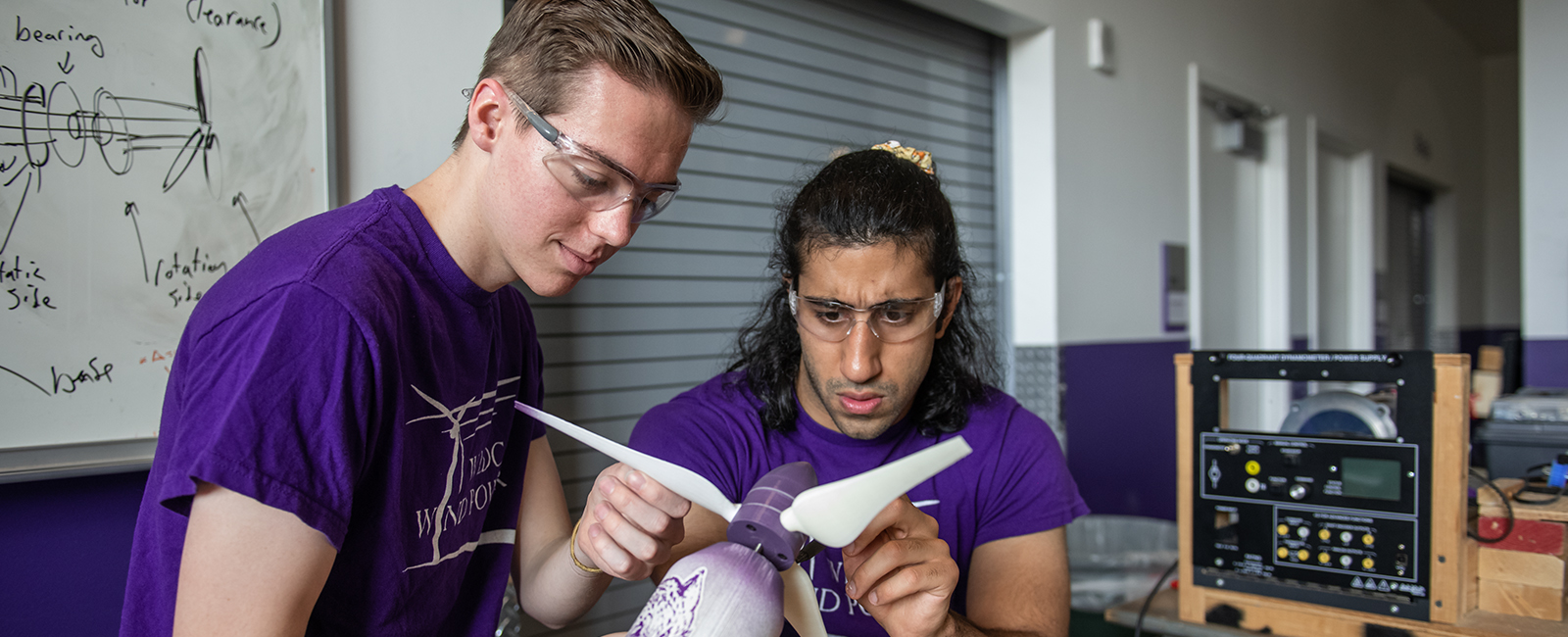 Two students from the Wildcat Wind Power team work on the turbine.